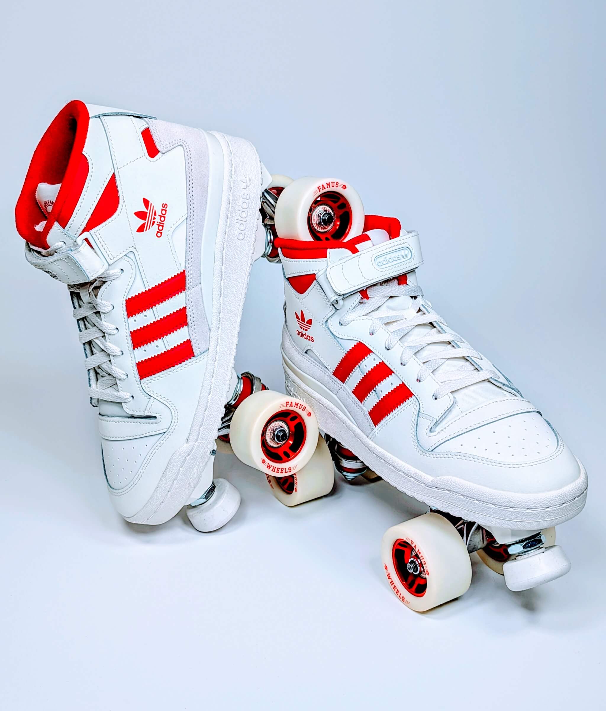 Loumy's Adidas Forum Redline roller sneakers with one tilted roller balanced on the other, showing red and white metallic components