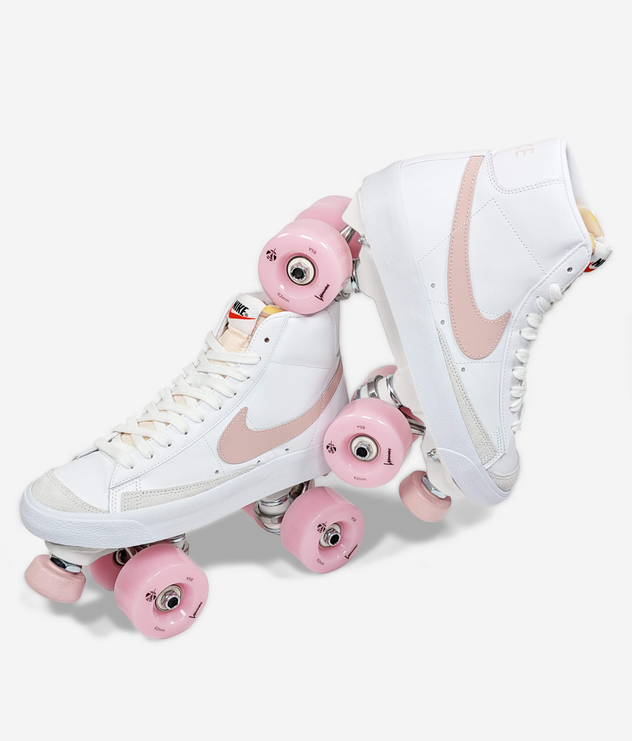 Loumy's Loumynous Blazer roller skate sneakers made from white Nike Blazer Mid ’77 with one tilted sneaker balanced on the other, featuring pink LED wheels