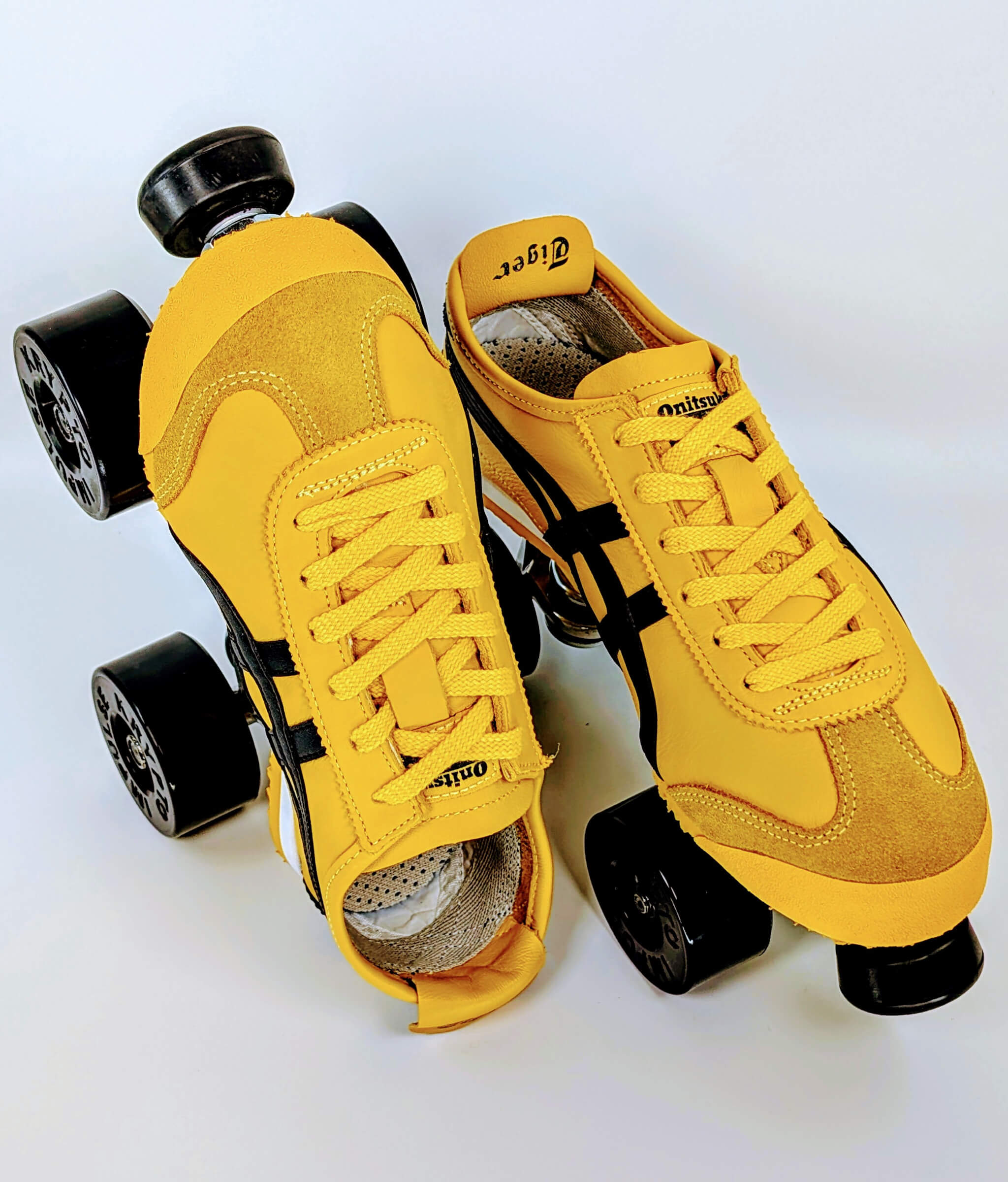 Loumy's Onitsuka Kill Bill roller sneakers in yellow and black, with one flat and the other standing on its heel, featuring black wheels