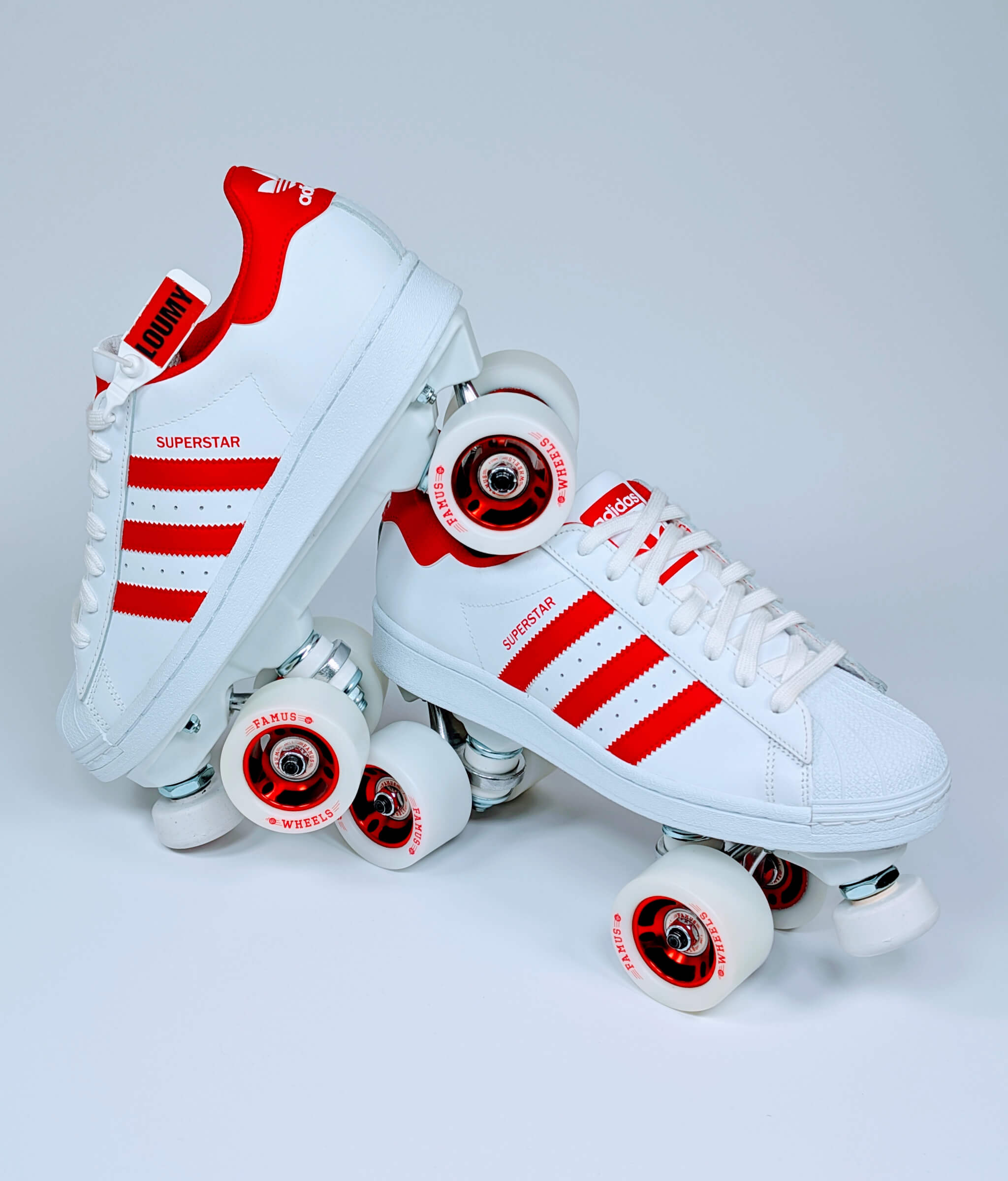 Loumy’s Adidas Superstar roller sneakers in white and red in a tilted view with red rim details