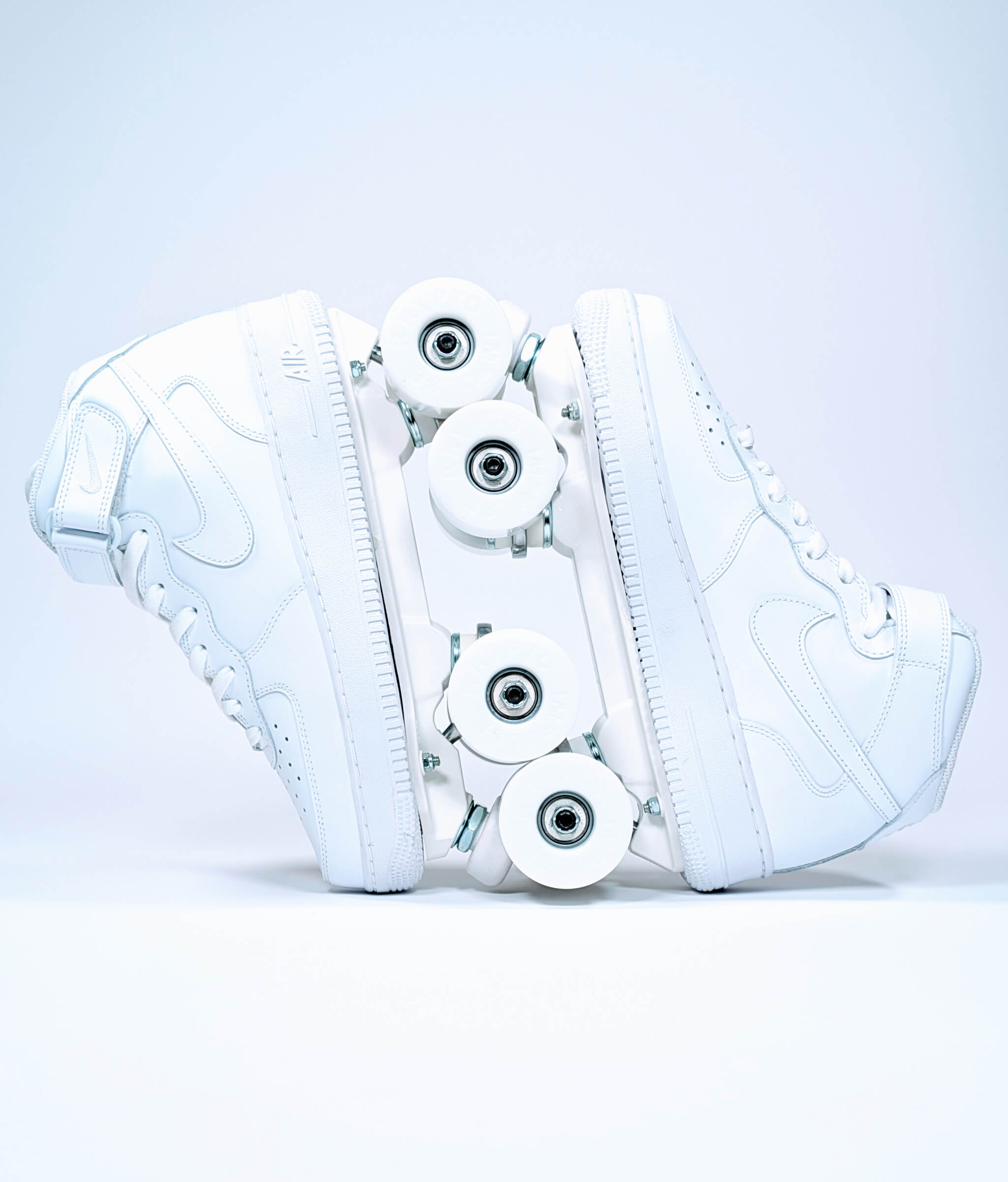 Loumy's Nike Air Force 1 Mid roller sneakers in white, displayed vertically with interlocked wheels