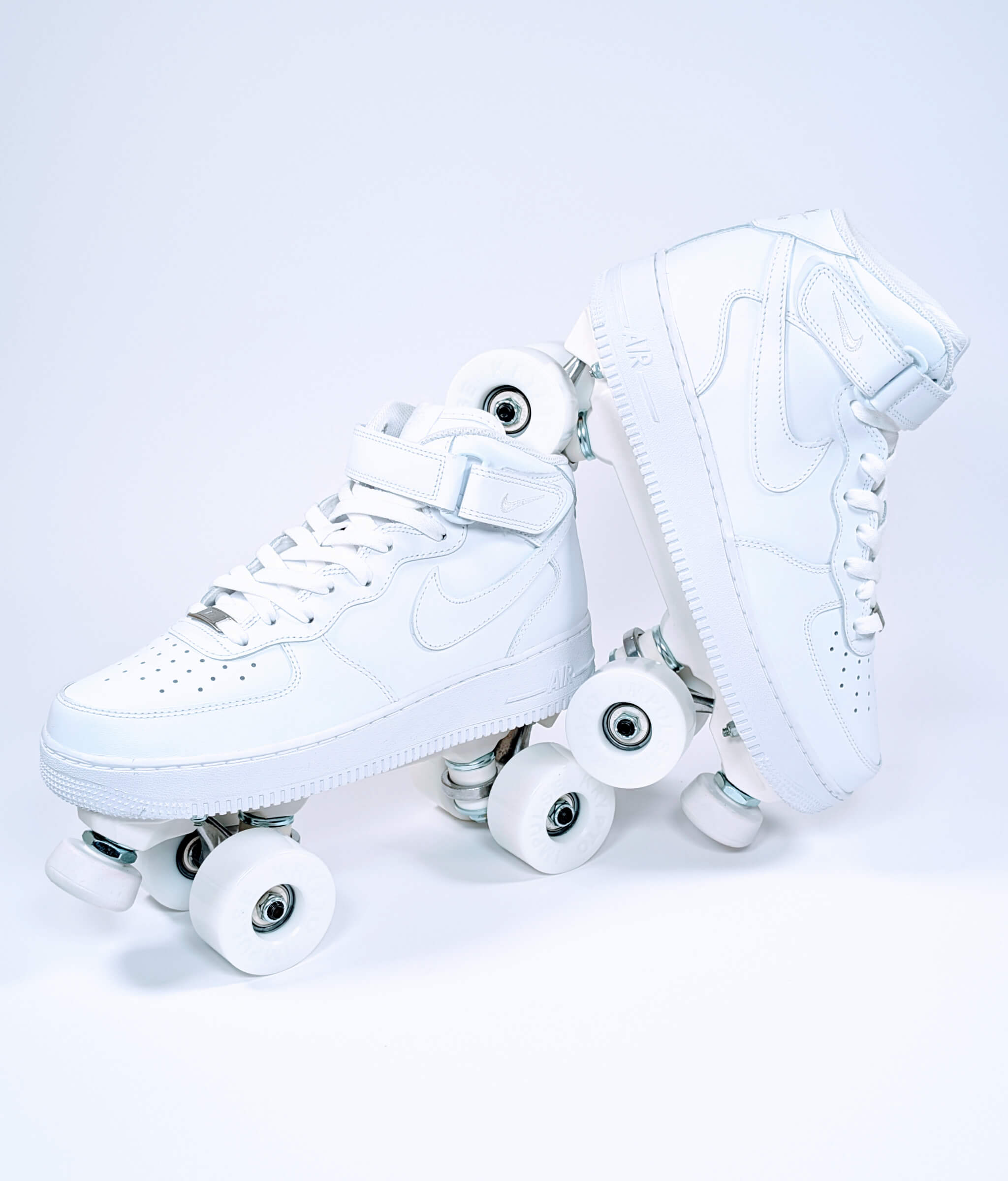Loumy roller sneakers made from white Nike Air Force 1 Mid, with one tilted and balanced on the other