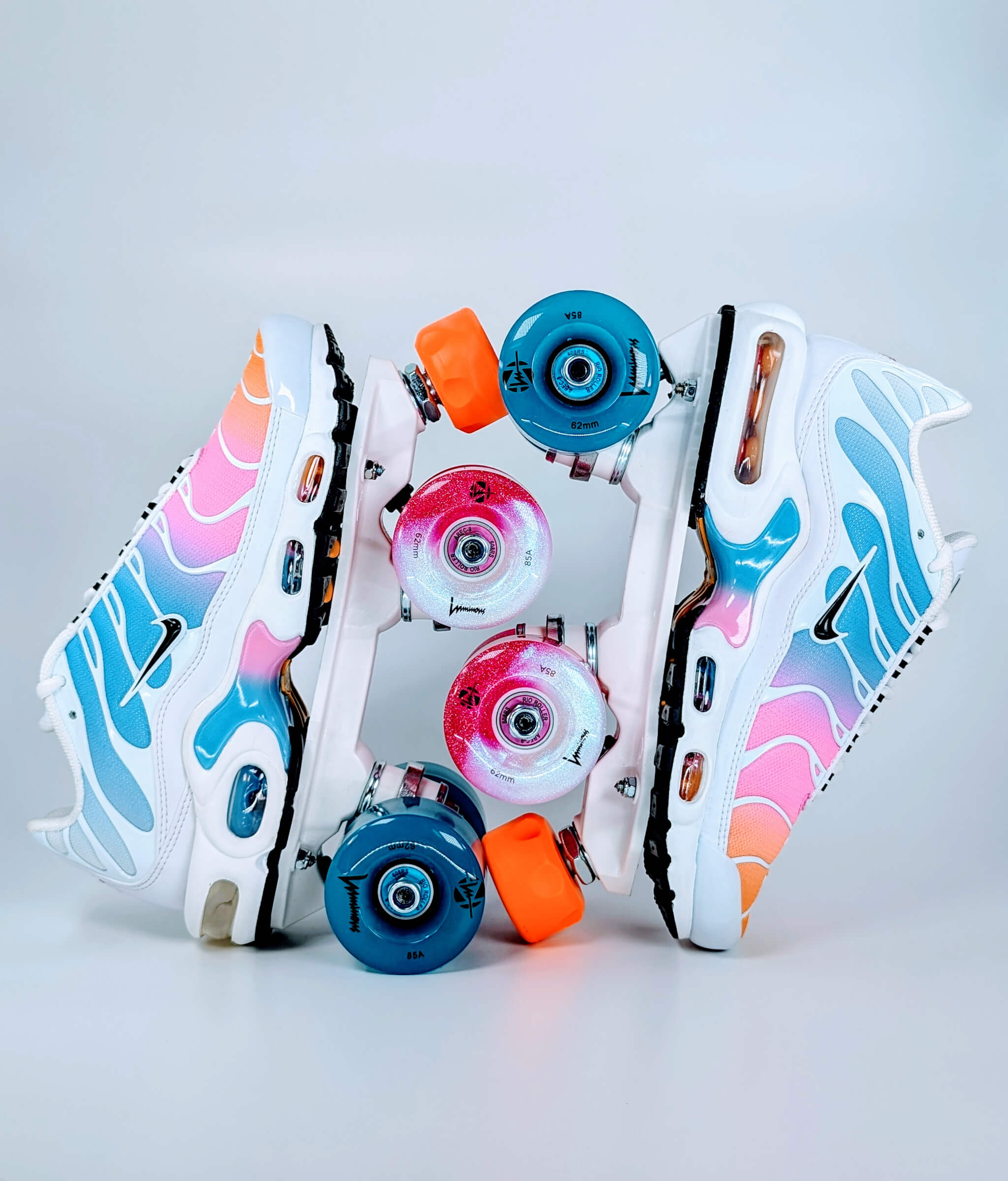 Loumy's Air Max Plus Summer Gradient roller sneakers in orange, pink and blue, displayed vertically with interlocked wheels, featuring glowing front and rear LED colors