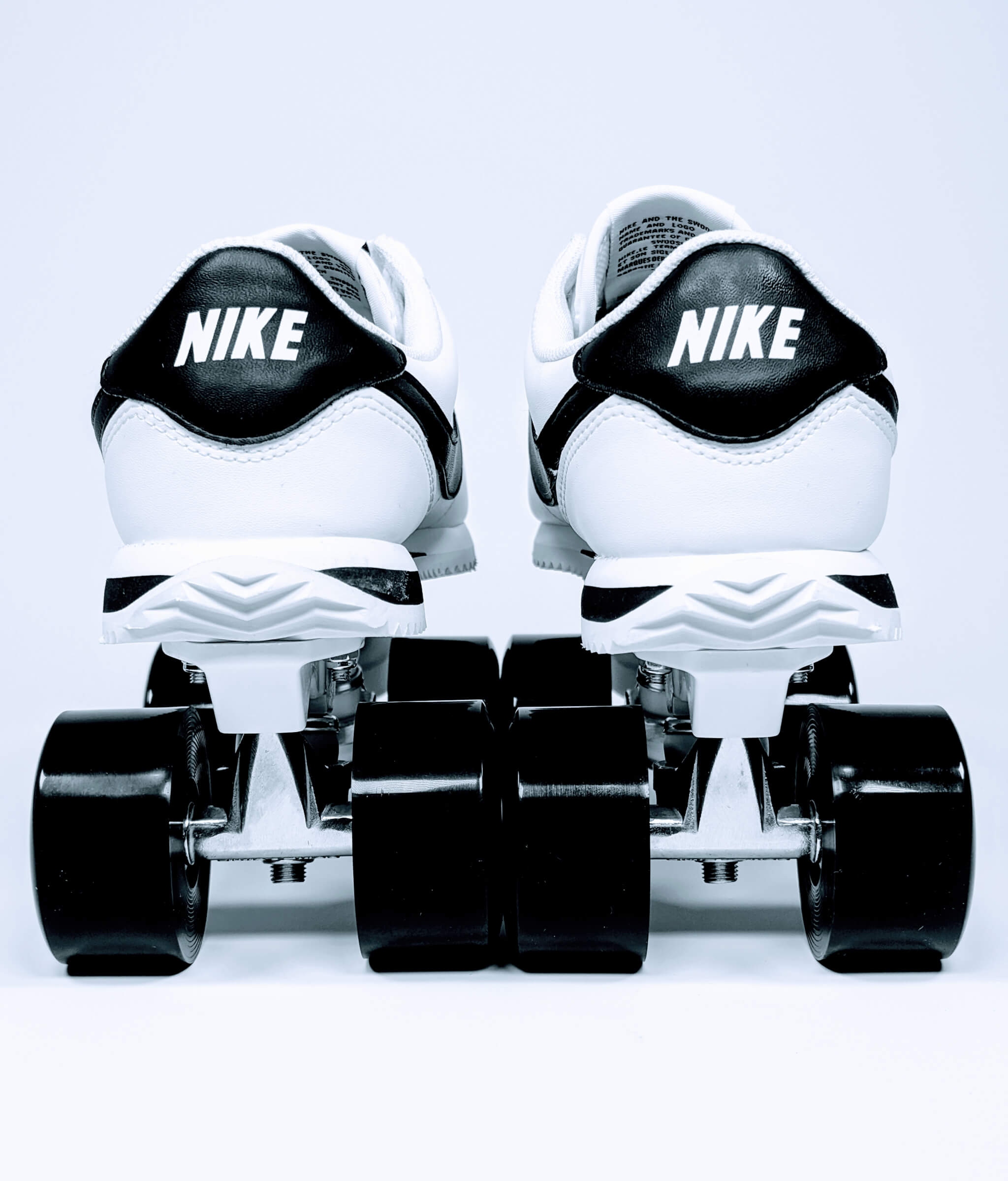 Nike Cortez roller sneakers by Loumy, back view in black and white with black wheels