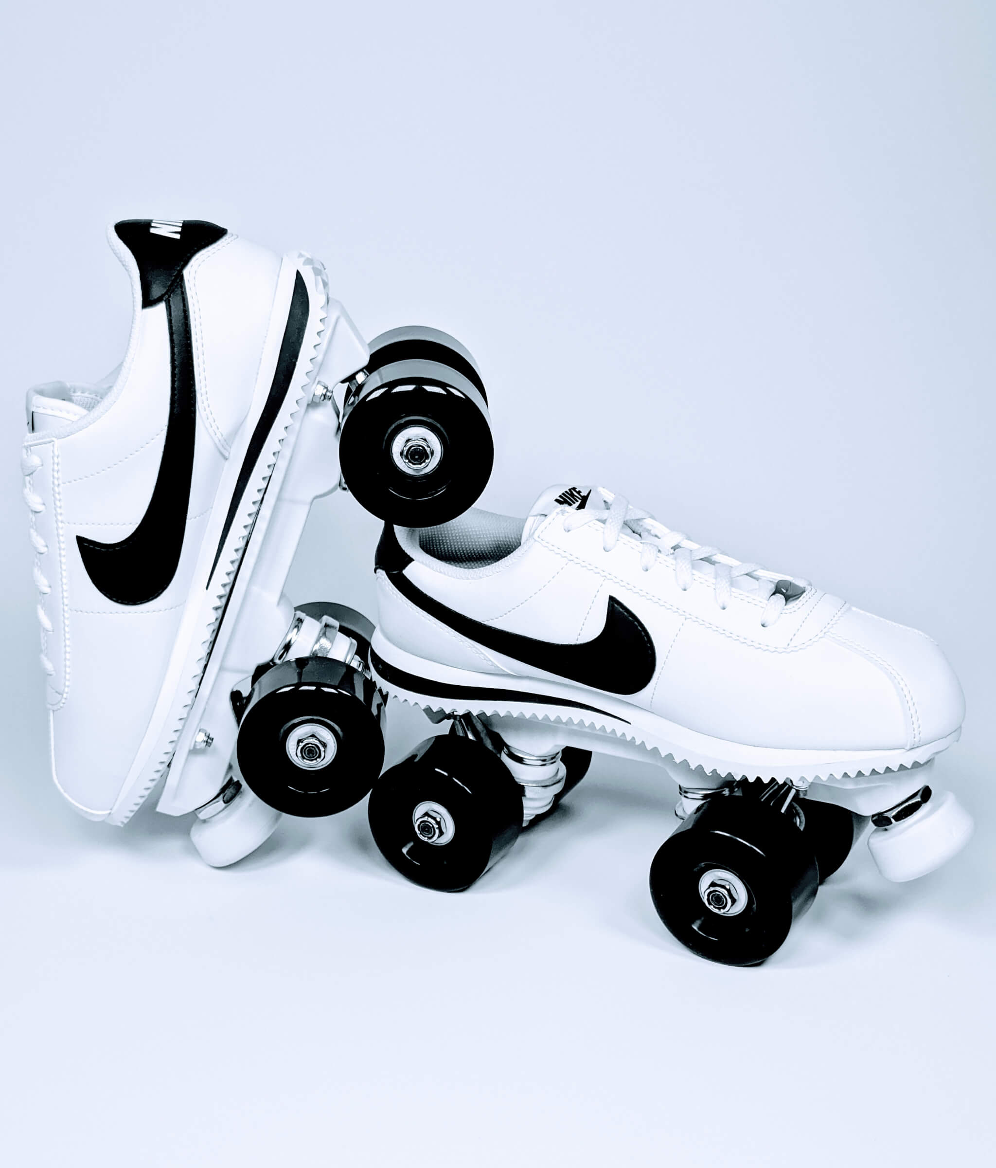 Nike Cortez roller sneakers by Loumy, tilted and balanced one on the other in black and white