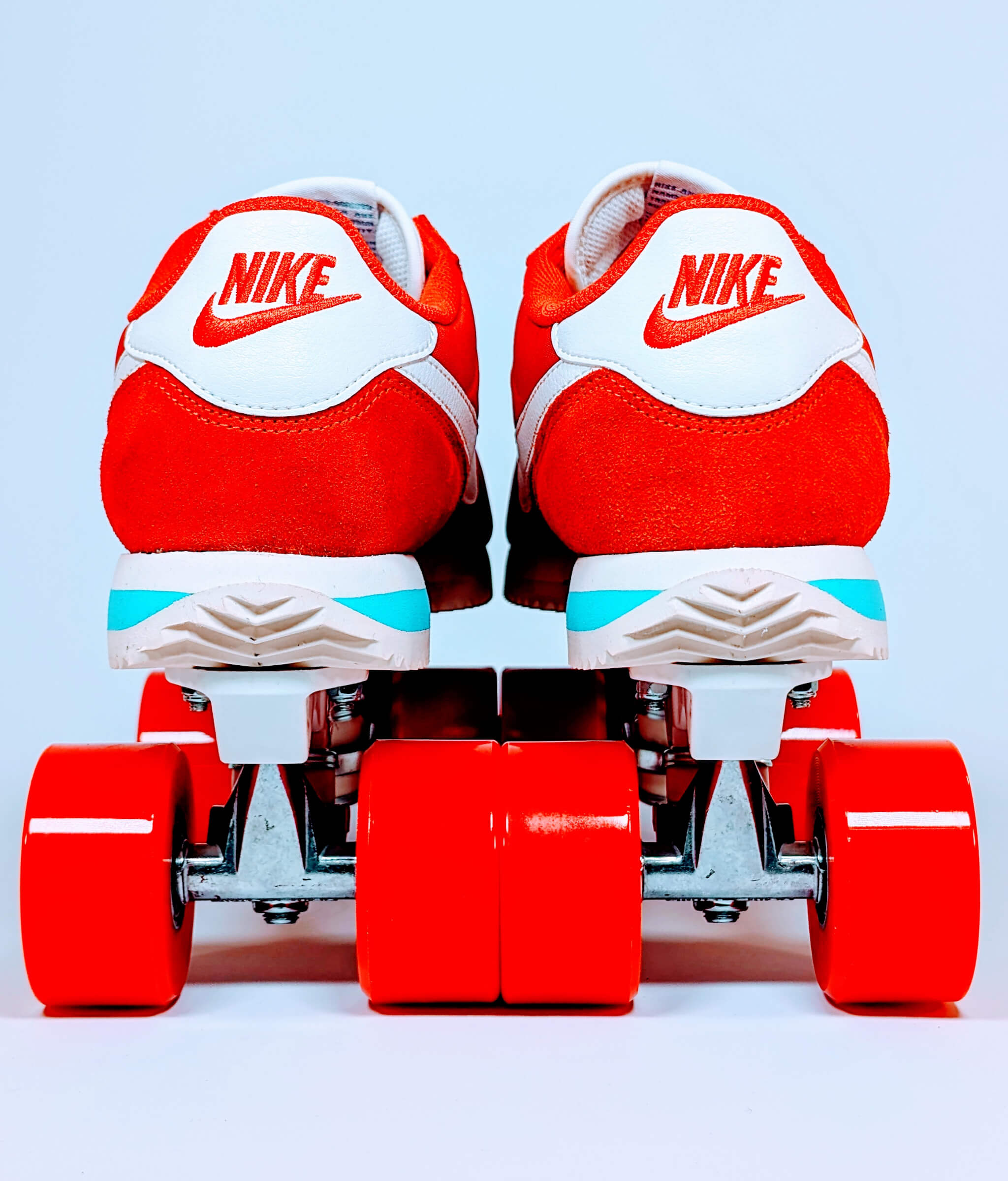 Back view of Loumy's red and white Nike Cortez roller sneakers with red wheels