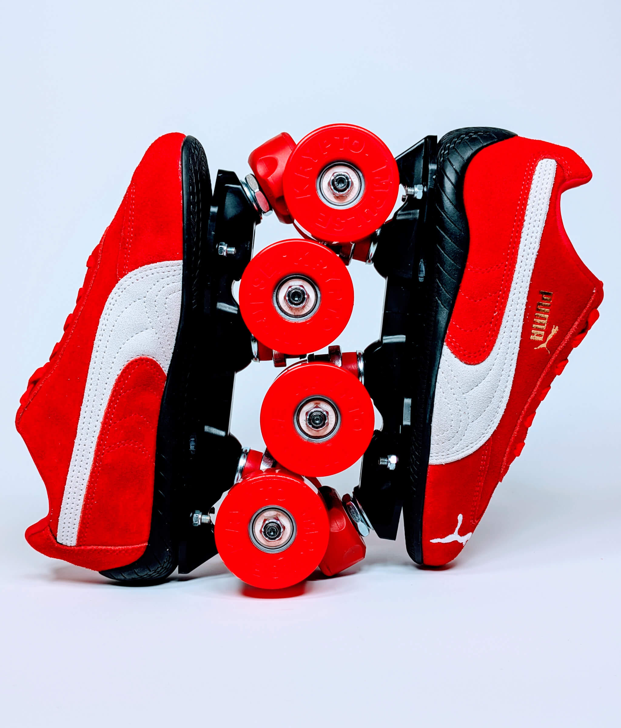 Red and black Speedcat OG roller sneakers by Loumy, displayed vertically with wheels interlocked