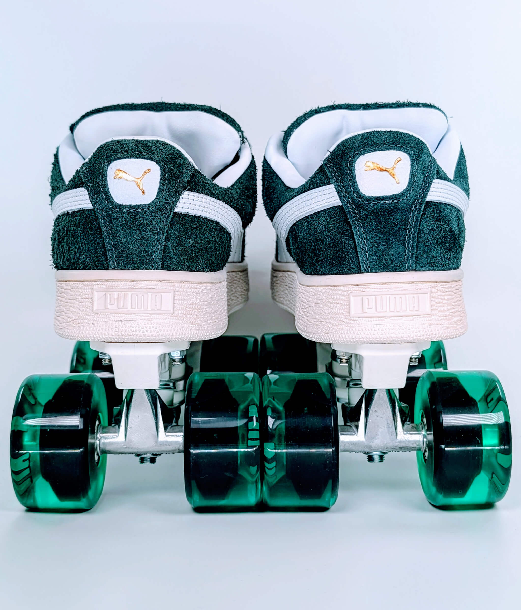 Back view of Loumy's dark green Puma XL Hairy Suede roller sneakers with translucent green wheels